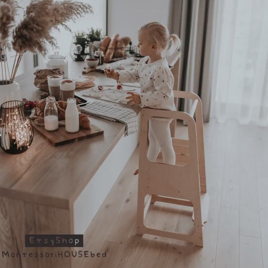 Child using non-foldable wooden Learning Tower, participating in kitchen activities